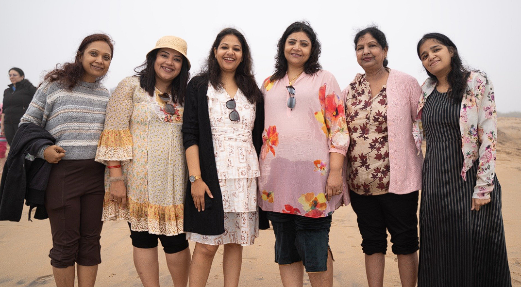 Group of women smiling together on the beach