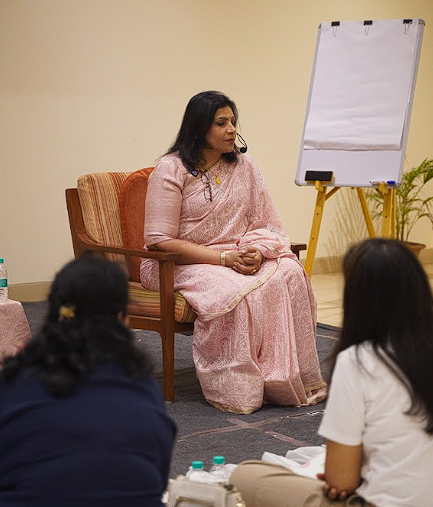 Dr. Monika seated in stillness, holding space for the group