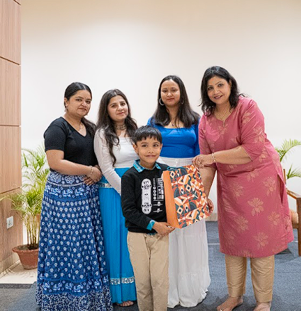 Dr. Monika presenting a gift to a family