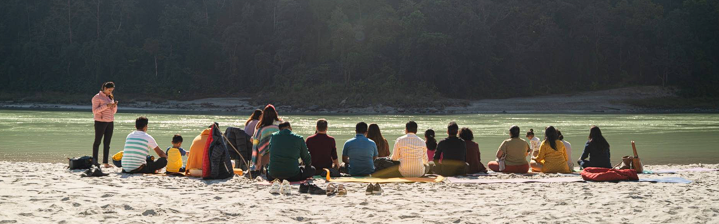 Families seated together at a Goa retreat circle at golden hour